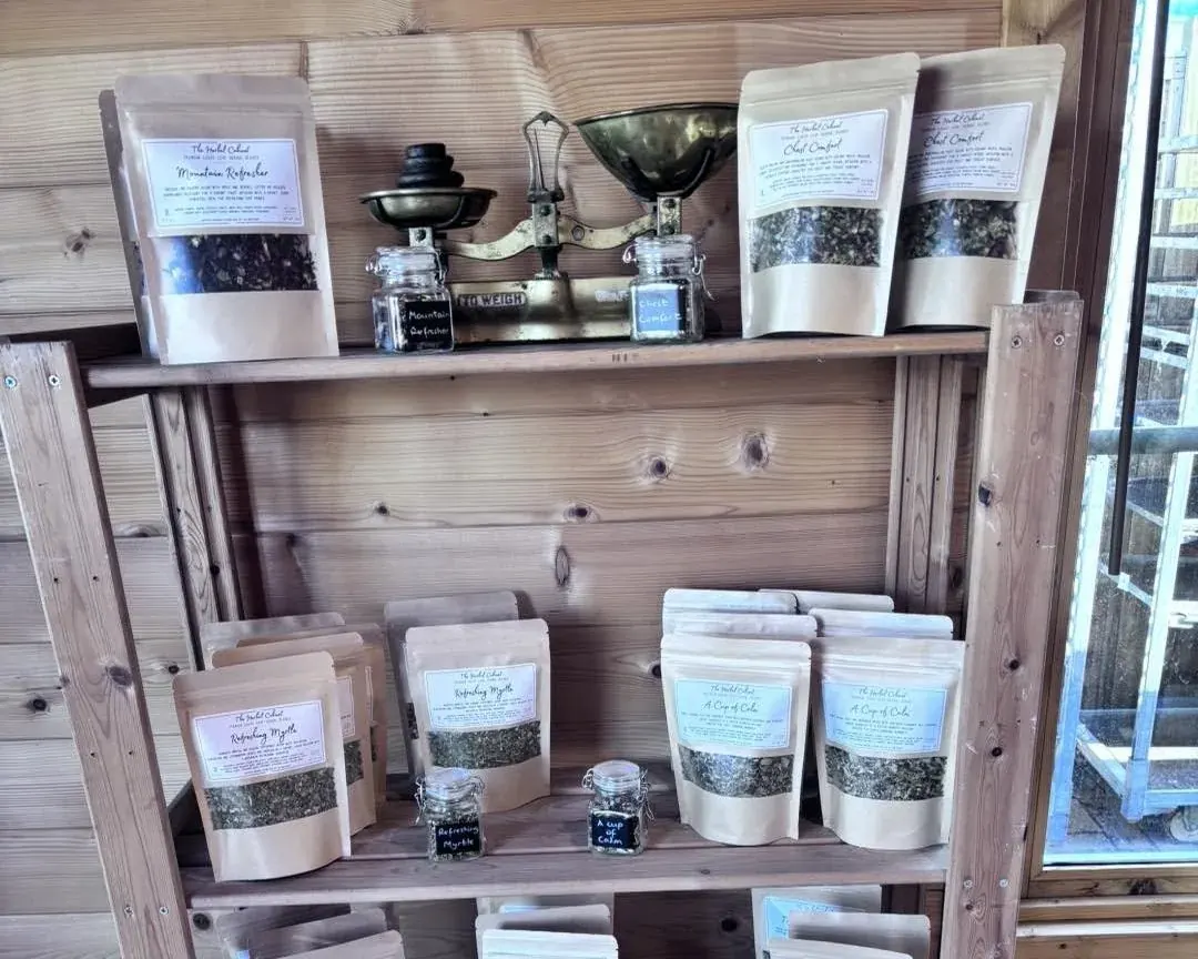 Loose-leaf herbal tea pouches and sample jars on wooden shelves at Westfield Nurseries, Whittlesey